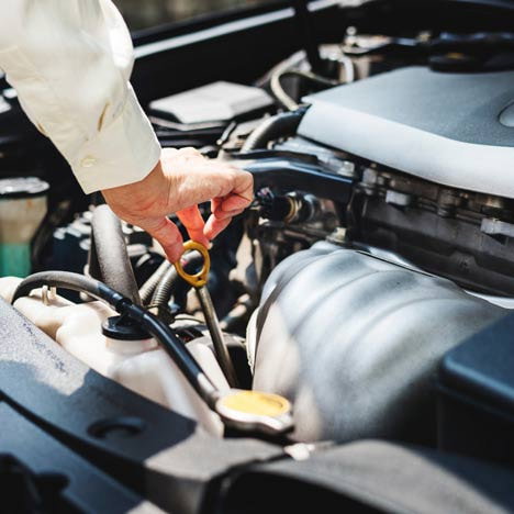 Technician inspecting a car engine under an Autoguard warranty repair