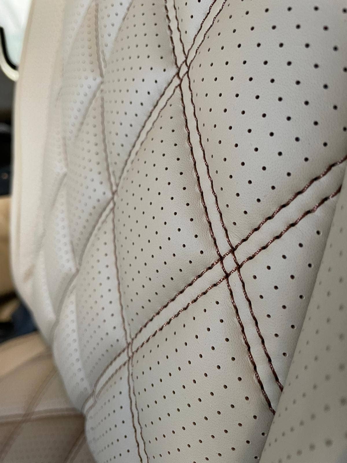 Perforated cream leather with contrast stitching, close up