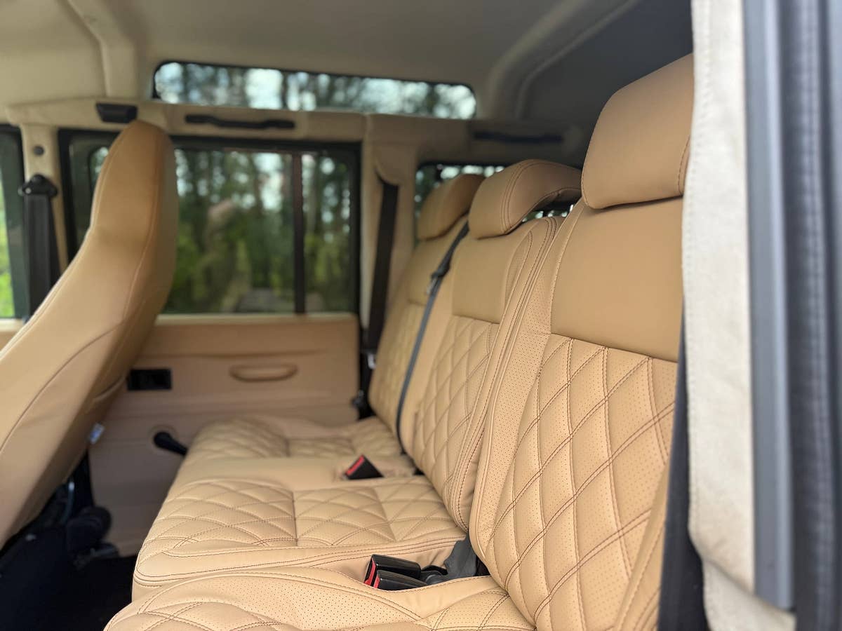 Cream quilted leather rear bench seating in a finished Defender